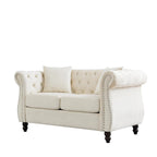 Divanetto Chesterfield in velluto beige, braccioli arrotolati, finiture con borchie
